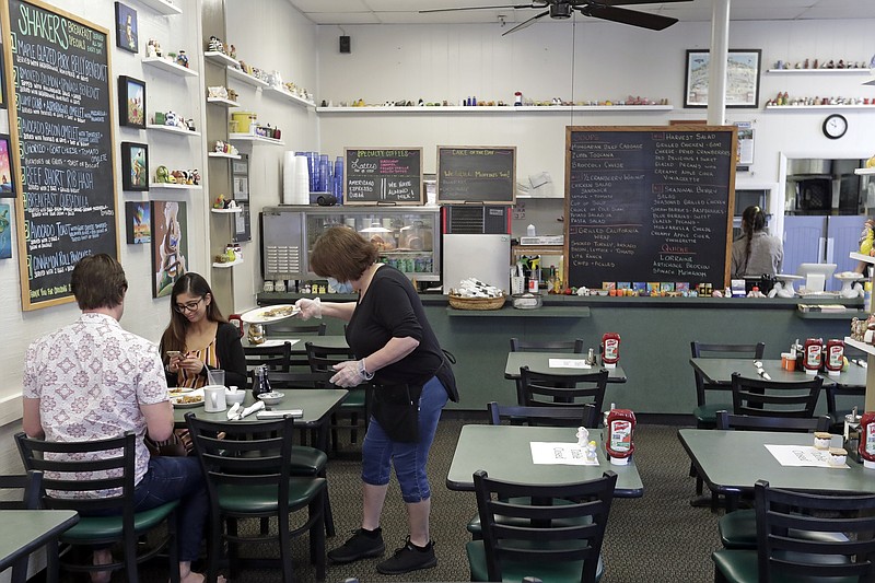 FILE - In this May 4, 2020 file photo, waitress Jill Lawrence. right, waits on customers at Shakers American Cafe Monday in Orlando, Fla. Restaurants, retailers and salons are desperately trying to stay afloat as the U.S. economy reopens in fits and starts after months in a coronavirus lockdown. But billions of dollars allocated by Congress as a lifeline to those very businesses are about to be left on the table when the government's Paycheck Protection Program stops accepting applications for loans Tuesday, June 29. (AP Photo/John Raoux, File)


