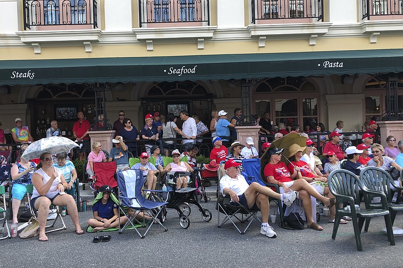 FILE - In this Oct. 3, 2019 file photo, supporters of President Donald Trump wait outside in a town square in The Villages, Fla., before an appearance by the president. There has always been a low-boil tension in The Villages between the Republican majority and the much smaller cohort of Democrats, but a veneer of good manners in "Florida's Friendliest Hometown" mostly prevailed on golf courses and at bridge tables. Those tensions got international attention last weekend when President Donald Trump tweeted approvingly of a video showing one of his supporters at the retirement community chanting a racist slogan associated with white supremacists. (AP Photo/Mike Schneider, File)


