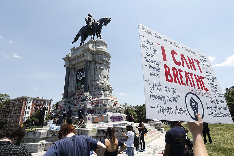 Photo by Steve Helber of The Associated Press / Virginia Lt. Gov. Justin Fairfax, left, speaks to protesters in front of the statue of Confederate General Robert E. Lee on Monument Avenue on June. 4, 2020, in Richmond, Virginia.