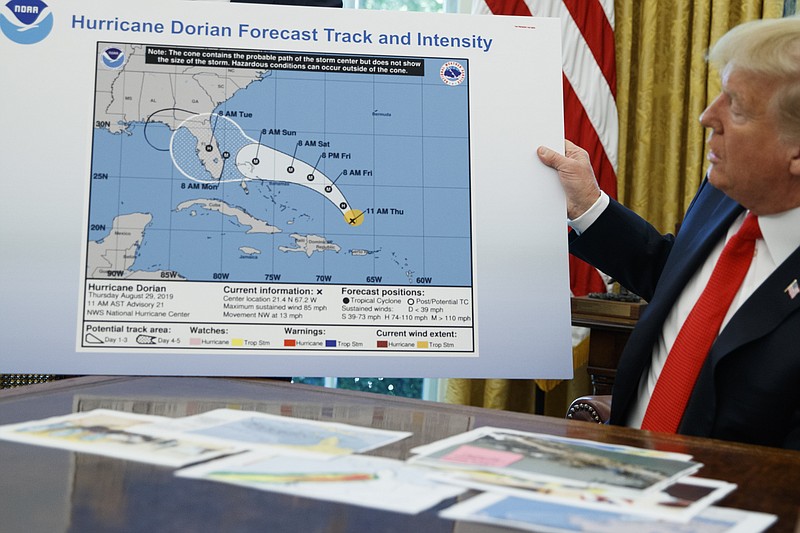 FILE - In this Sept. 4, 2019, file photo, President Donald Trump holds a chart as he talks with reporters after receiving a briefing on Hurricane Dorian in the Oval Office of the White House in Washington. A government watchdog says the Commerce Department is trying to block the findings of an investigation into the agency's role in rebuking forecasters who contradicted President Donald Trump's inaccurate claims about the path of Hurricane Dorian in 2019. (AP Photo/Evan Vucci. File)


