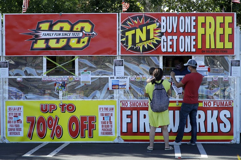 People purchase fireworks on Thursday, July 2, 2020, in Dublin, Calif. For many Americans, the Fourth of July won't be about big festivities but setting off fireworks themselves. Hundreds of cities and towns have canceled shows Saturday because of the coronavirus pandemic, and sales of consumer fireworks are booming; though officials are concerned about fires and injuries with more pyrotechnics going off in backyards and at block parties. (AP Photo/Ben Margot)


