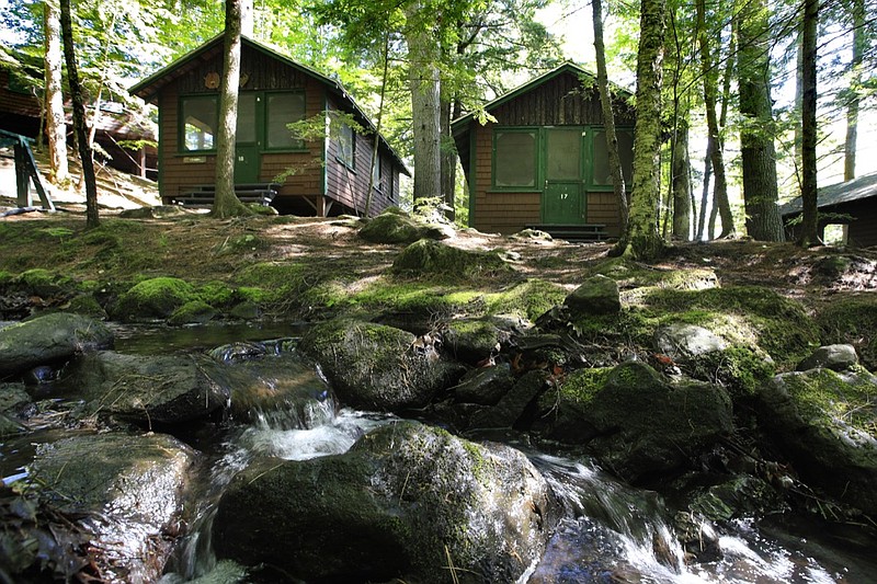 In this Thursday, June 4, 2020 photo, cabins awaits campers at the Camp Winnebago summer camp in Fayette, Maine. The boys camp is going ahead with plans to open with a reduction in the number of campers and other changes to comply with guidelines for helping prevent the spread of the coronavirus. Many of the nation's 15,000-plus summer camps opting to close because of health concerns surrounding the pandemic, or because of delays in receiving rules or guidelines from licensing officials. (AP Photo/Robert F. Bukaty)