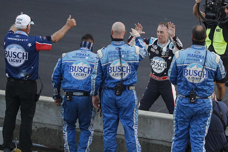 AP photo by Darron Cummings / NASCAR driver Kevin Harvick, on far side of wall, celebrates with his Stewart-Haas Racing No. 4 Ford crew after winning Sunday's Cup Series race at Indianapolis Motor Speedway.