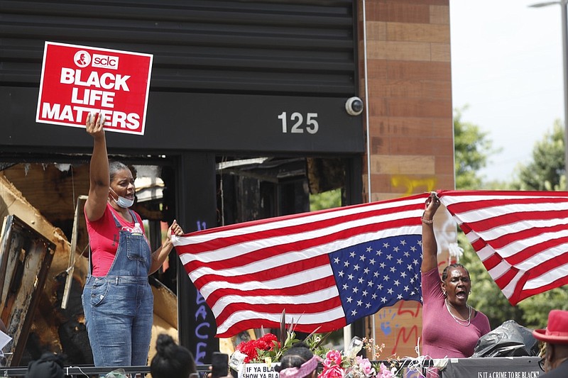 Protesters chant outside a Wendy's restaurant on Tuesday, June 23, 2020, in Atlanta after a funeral for Rayshard Brooks was held. Brooks died after being fatally shot by an Atlanta police officer. (AP Photo/John Bazemore)