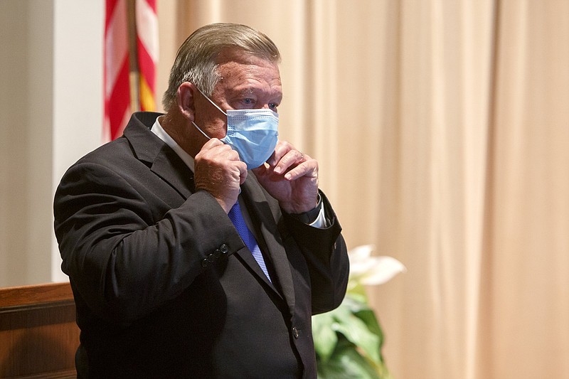 Staff photo by C.B. Schmelter / Mayor Jim Coppinger replaces his mask after speaking during a press conference at the Hamilton County Health Department's Golley Auditorium on Monday, July 6, 2020 in Chattanooga, Tenn. Mayor Coppinger said that people in Hamilton County will be required to wear a mask or face covering in public starting after midnight on July 10. Citizens who refuse to cover their face could receive a Class C misdemeanor, with penalties ranging from a $50 fine up to 30 days in jail.
