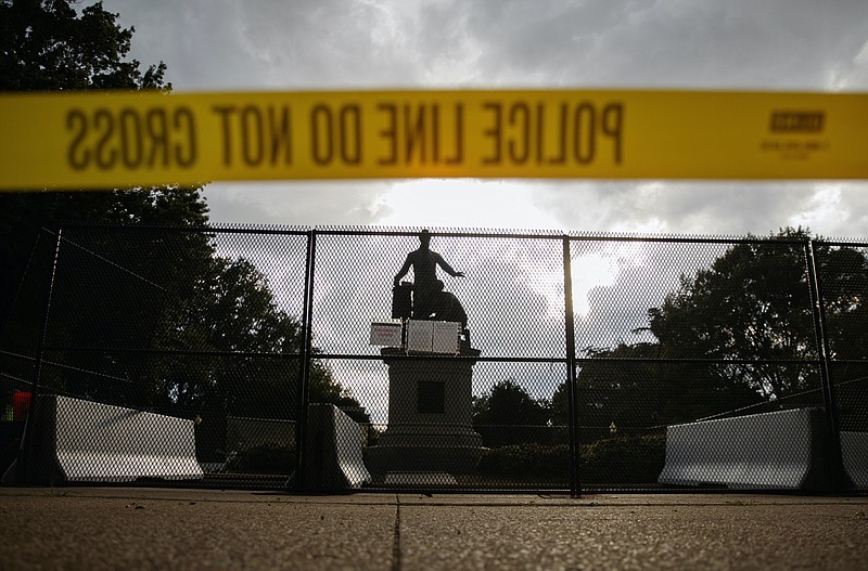 AP Photo, Carolyn Kaster / Yellow police tape and concrete barricades and fencing surround the Emancipation Memorial in Lincoln Park in Washington, Thursday, June 25, 2020. The Emancipation Memorial depicts a freed slave kneeling at the feet of President Abraham Lincoln. Calls are intensifying for the removal of the statue as the nation confronts racial injustice.