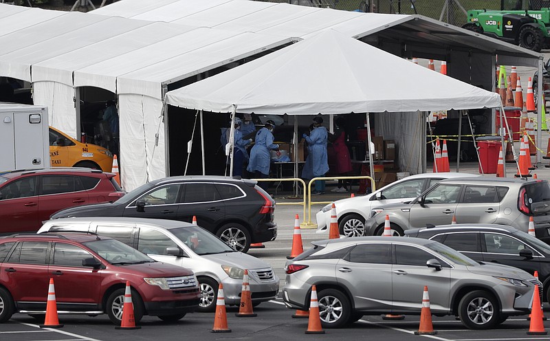 Lines of cars wait at a drive-through coronavirus testing site, Sunday, July 5, 2020, outside Hard Rock Stadium in Miami Gardens, Fla. Florida health officials say the state has reached a grim milestone: more than 200,000 people have tested positive for the novel coronavirus since the start of the outbreak. (AP Photo/Wilfredo Lee)