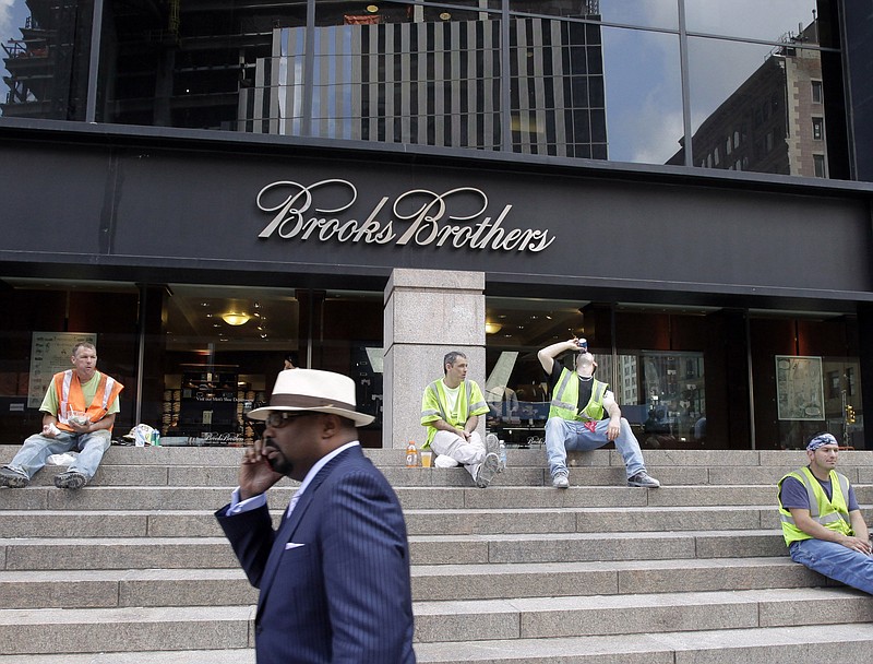 In this Aug. 4, 2011, file photo, a man passes a Brooks Brothers store on Church Street in New York's financial district. The 200-year-old fashion retailer that says it's put 40 U.S. presidents in its suits, is filing for bankruptcy protection on Wednesday, July 8, 2020. (AP Photo/Mark Lennihan, File)