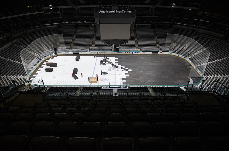 FILE - In this March 12, 2020, file photo, crews cover the ice at American Airlines Center in Dallas, home of the Dallas Stars hockey team, after the NHL season was put on hold due to the coronavirus. (Ashley Landis/The Dallas Morning News via AP, File)


