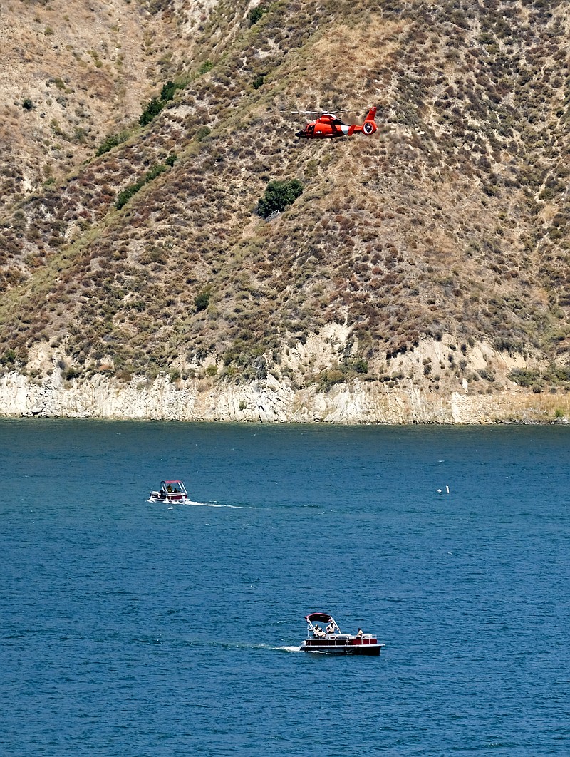 A U.S. Coast Guard helicopter helps in the search for former "Glee" actress Naya Rivera, Thursday, July 9, 2020 at Lake Piru in Los Padres National Forest, Calif., northwest of Los Angeles. Rivera rented a boat Wednesday and her 4-year-old son was found alone on the boat. (AP Photo/Ringo H.W. Chiu)