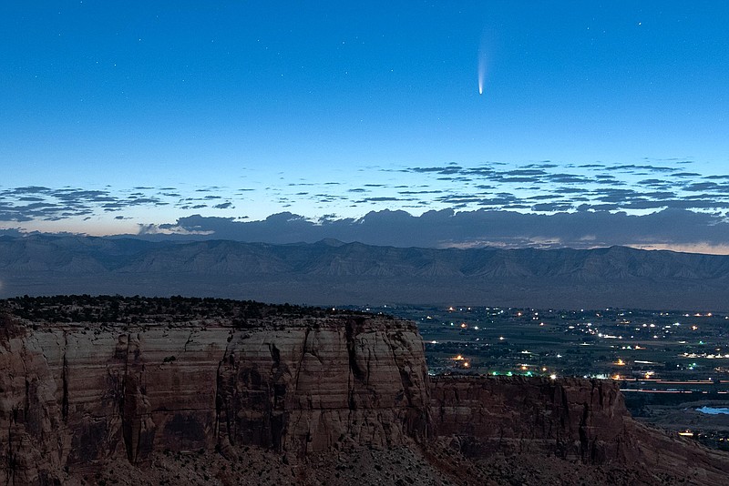 Comet Neowise soars in the horizon of the early morning sky in this view from the near the grand view lookout at the Colorado National Monument west of Grand Junction, Colo., Thursday, July 9, 2020. The newly discovered comet is streaking past Earth, providing a celestial nighttime show after buzzing the sun and expanding its tail. (Conrad Earnest via AP)