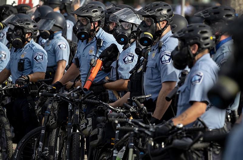 In this May 27, 2020, file photo, police gather en masse as protests continue at the Minneapolis 3rd Police Precinct in Minneapolis. More than 150 Minneapolis police officers have started the process of filing for disability claims since the death of George Floyd and the ensuing unrest in the city, with the majority citing post-traumatic stress disorder as the reason for their planned departure, according to an attorney representing the officers. (Carlos Gonzalez/Star Tribune via AP, File)