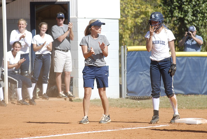 Staff photo / Gordon Lee softball player Kendall Johnson, right, gets a hand from coach Dana Mull and the rest of the team after hitting a two-run double, then stealing third base in the bottom of the second inning against Mountain Pisgah Christian on Oct 20, 2010, in Chickamauga, Ga.