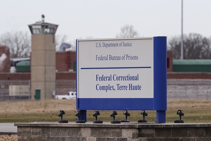 FILE - In this Dec. 10, 2019, file photo the guard tower flanks the sign at the entrance to the U.S. Penitentiary in Terre Haute, Ind. The Justice Department plans to resume federal executions next week for the first time in more than 15 years, despite the coronavirus pandemic raging both inside and outside prisons and stagnating national support for the death penalty. Three people are slated to die by lethal injection in one week beginning Monday. The executions will take place at USP Terre Haute. (AP Photo/Michael Conroy, File)