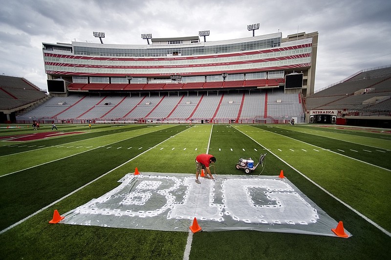 AP photo by Jacob Hannah / Turf manager Jared Hertzel touches up the newly painted Big Ten conference logo on the football field at Memorial Stadium on Oct, 6, 2011, in Lincoln, Neb.