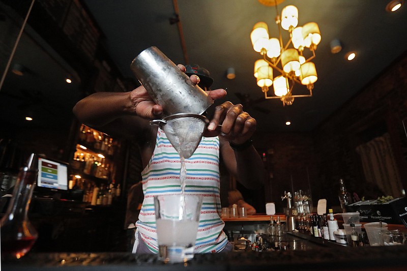 FILE - In this Thursday, July 9, 2020 file photo, a bartender makes a cocktail in New Orleans. A report released Wednesday, July 15, 2020, finds if you decide to have an alcoholic drink, limiting yourself to one a day is best — whether you're a man or woman. (AP Photo/Gerald Herbert)


