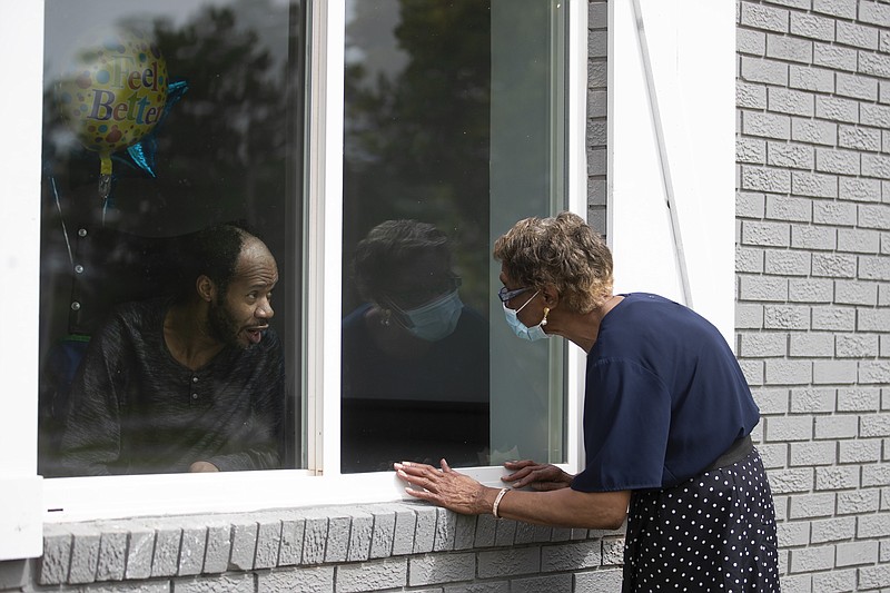 Southern Pines nursing home resident Wayne Swint gets a birthday visit from his mother, Clemittee Swint, in Warner Robins, Ga., on Friday, June 26, 2020. Face to face visits are not allowed but staff members help arrange window visits. (AP Photo/John Bazemore)