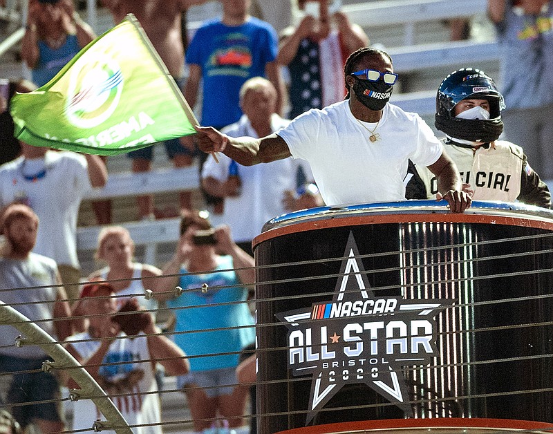 AP photo by David Crigger / Former University of Tennessee and current New Orleans Saints running back Alvin Kamara waves the green flag to start the NASCAR All-Star Race on Wednesday at Bristol Motor Speedway.