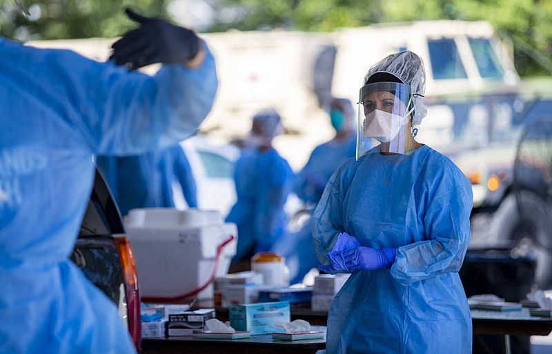 A Tidelands Health medical professional changes latex gloves during a drive-through COVID-19 testing site Friday July 17, 2020 at Myrtle Beach Pelicans Ballpark in Myrtle Beach, S.C. (Josh Bell/The Sun News via AP)


