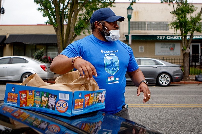 Staff photo by C.B. Schmelter / Troy Rogers passes out lunches near the Chattanooga Community Kitchen on Tuesday, May 5, 2020 in Chattanooga, Tenn.