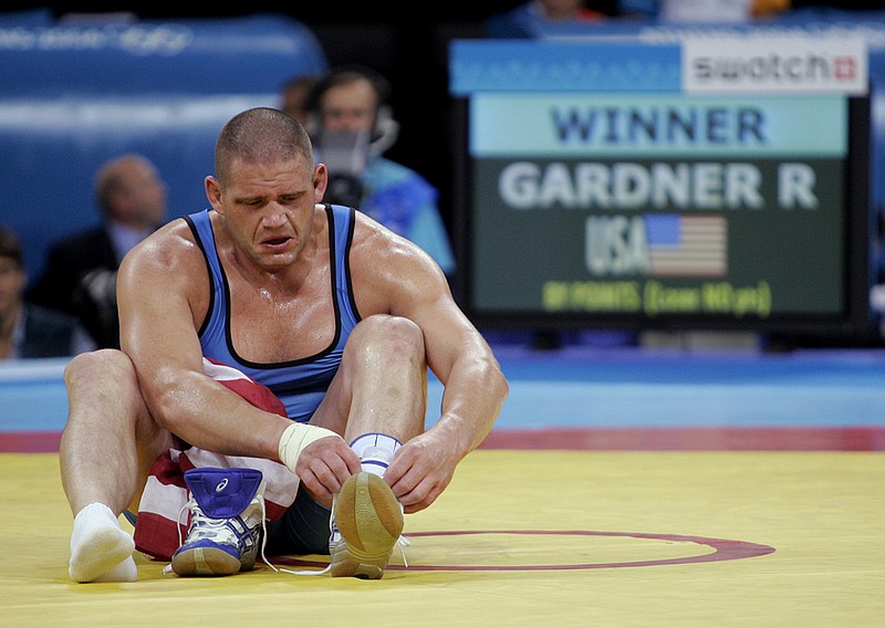 AP photo by Mark J. Terrill / U.S. wrestler Rulon Gardner takes off his shoes to symbolize his retirement after defeating Iran's Sajad Barzi in a Greco-Roman bronze-medal match at the Athens Olympics on Aug. 25, 2004.