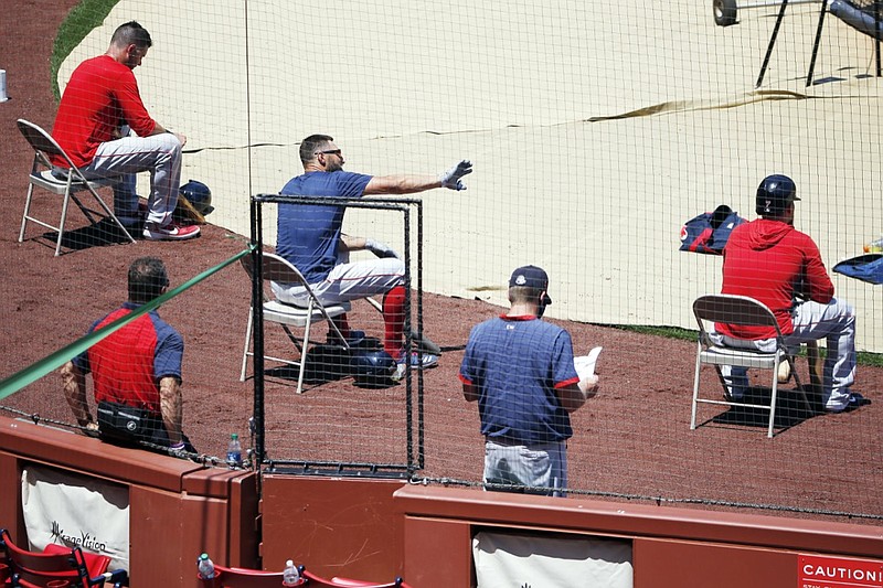 AP photo by Michael Dwyer / The Boston Red Sox sit apart in hopes of limiting the risk of spreading the coronavirus during practice July 5 at Fenway Park in Boston.