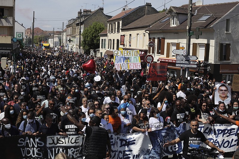 Demonstrators holding a placard reading "Generation Adama-Climate, we want to breathe" take part of a march to mark the fourth anniversary of the death of Adama Traore, a Black man in police custody, whose case has mobilized broad anger against police brutality and racial injustice, in Beaumont Sur Oise, north suburb of Paris, Saturday, July 18, 2020. The demonstration in Beaumont sur Oise is honoring Adama Traore, who died on his 24th birthday in July 2016 after an arrest in circumstances that remain unclear. But it's also about broader anti-government grievances, and climate activists are co-organizing this year's protest. (AP Photo/Rafael Yaghobzadeh)