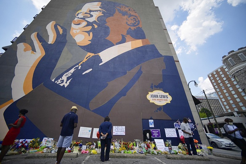 People gather at a make-shift memorial near the home of Rep. John Lewis, D-Ga., Sunday, July 19, 2020, in Atlanta. Lewis, who died Friday at age 80, was the youngest and last survivor of the Big Six civil rights activists who organized the 1963 March on Washington, and spoke shortly before the group's leader, Rev. Martin Luther King Jr., gave his "I Have a Dream" speech to a vast sea of people. (AP Photo/Mike Stewart)