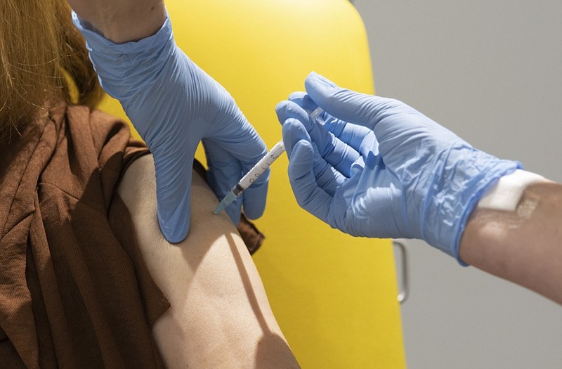 In this handout photo released by the University of Oxford a volunteer participates in the vaccine trial in Oxford, England on July 7, 2020. Scientists at Oxford University say their experimental coronavirus vaccine has been shown in an early trial to prompt a protective immune response in hundreds of people who got the shot. In research published Monday July 20, 2020 in the journal Lancet, scientists said that they found their experimental COVID-19 vaccine produced a dual immune response in people aged 18 to 55. (University of Oxford via AP)