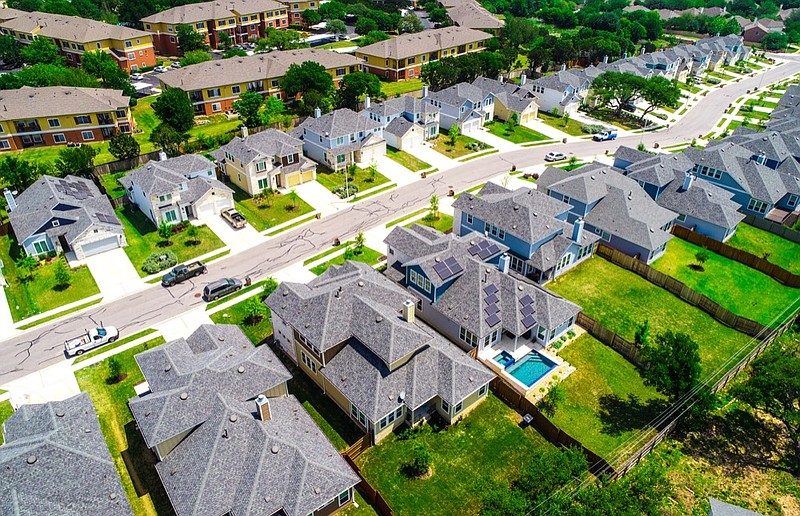 Aerial drone view looking down on new development and new neighborhood- Aerial drone view above suburb rooftops in long line of new homes  housing expensive home house tile rich life tile / Getty Images
