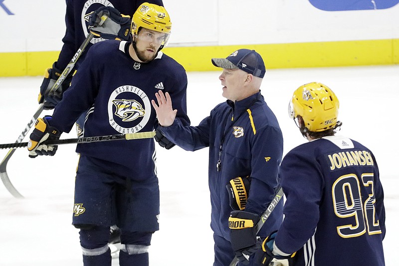 AP photo by Mark Humphrey / Nashville Predators coach John Hynes, center, talks with right wing Viktor Arvidsson, left, and center Ryan Johansen during practice July 14 in Nashville.