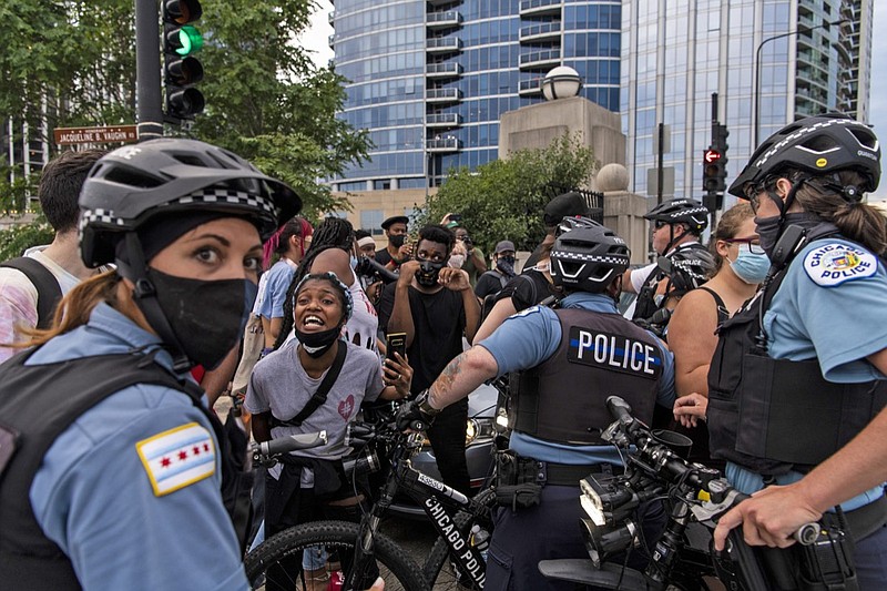 Chicago police and activists crowd around a vehicle that tried to drive through the protesters circle at the intersection of Roosevelt Rd. and Columbus Dr, Monday, July 20, 2020 in Chicago. (Tyler LaRiviere/Chicago Sun-Times via AP)