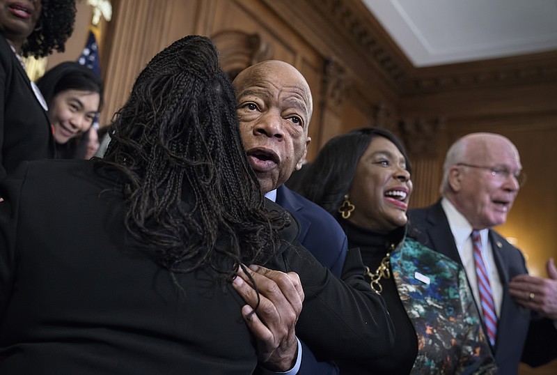 Photo by J. Scott Applewhite of The Associated Press / In this Dec. 6, 2019 file photo, civil rights leader Rep. John Lewis, D-Georgia, is hugged as House Democrats gathered before passing the Voting Rights Advancement Act to eliminate potential state and local voter suppression laws at the Capitol in Washington.