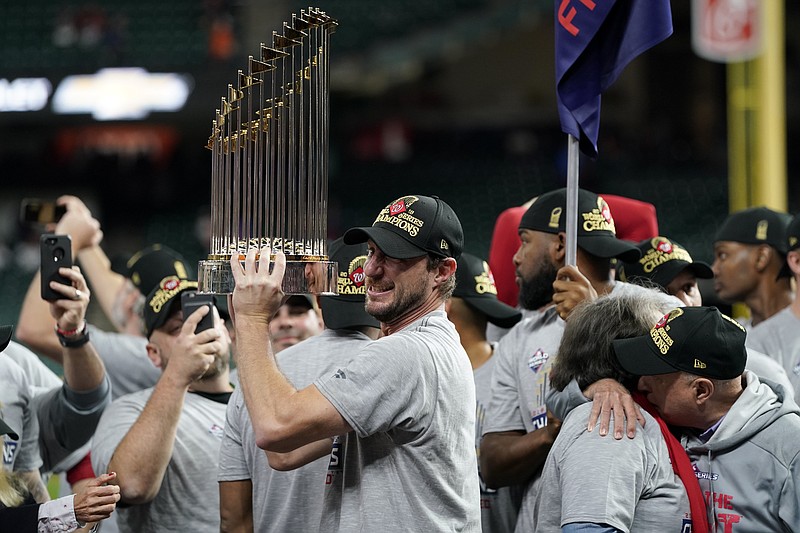 AP photo by David J. Phillip / Washington Nationals starting pitcher Max Scherzer celebrates with the championship trophy after Game 7 of the 2019 World Series against the host Houston Astros last Oct. 30.