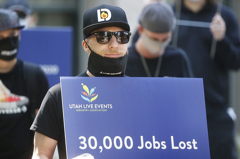 Special events workers who were forced out of work because of the COVID-19 pandemic marched Tuesday, July 21, 2020, in Salt Lake City. Marchers organized by Utah Live Event Industry Association aimed to draw attention and legislative support to the people and businesses who put on concerts, theater, sports, and other live events which mostly have gone dark since the COVID-19 pandemic hit in March. They're called it a "peaceful walk for work." The silent parade showcased families struggling to make ends meet since events have been canceled, with no end to the restrictions in sight. (AP Photo/Rick Bowmer)