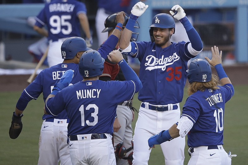 Los Angeles Dodgers' Cody Bellinger (35) is met at home plate after hitting a grand slam during the first inning of an exhibition baseball game against the Arizona Diamondbacks Sunday, July 19, 2020, in Los Angeles. (AP Photo/Marcio Jose Sanchez)