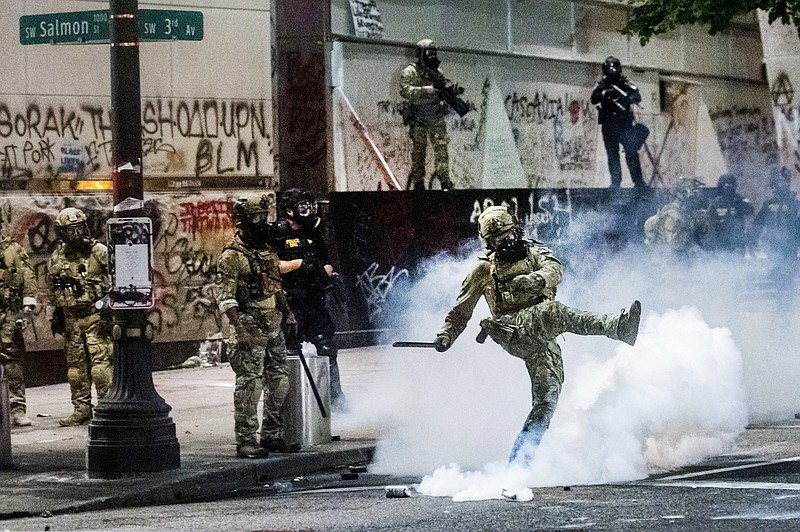 Federal officers use crowd control munitions to disperse Black Lives Matter protesters outside the Mark O. Hatfield United States Courthouse on Tuesday, July 21, 2020, in Portland, Ore. (AP Photo/Noah Berger)


