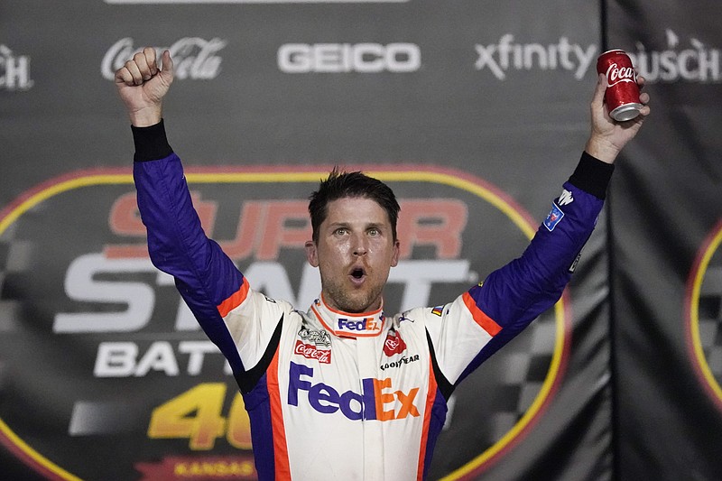 AP photo by Charlie Riedel / NASCAR driver Denny Hamlin celebrates after winning Thursday night's Cup Series race at Kansas Speedway.