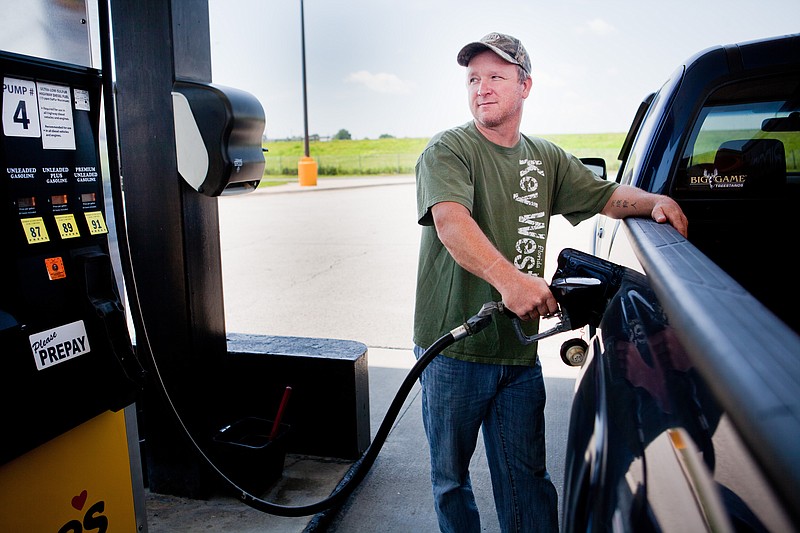 FILE - In this July 1, 2014 file photo, Lance Thompson pumps gas into his truck at a Love's station in St. Joseph, Mo. (AP Photo/St. Joseph News-Press, Sait Serkan Gurbuz, File)