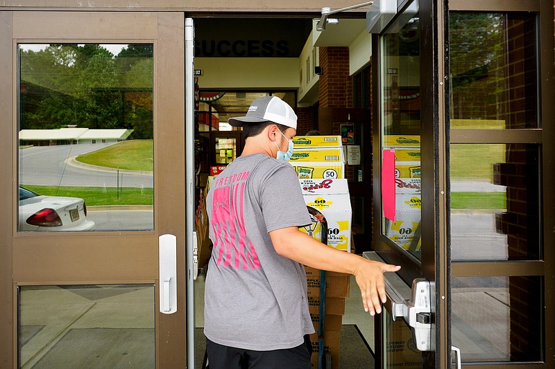 Staff photo by C.B. Schmelter / Pacey Smith helps deliver snacks for the vending machines at Chattooga County High School on Tuesday, July 28, 2020 in Summerville, Ga. Thursday is the first day of school for over 2,600 students in the Chattooga County Schools system. As other districts around the state delayed their back-to-school days or moved to all-remote learning, Chattooga County school officials are going ahead with its plan to start school Thursday, one of the earliest start days in the nation.