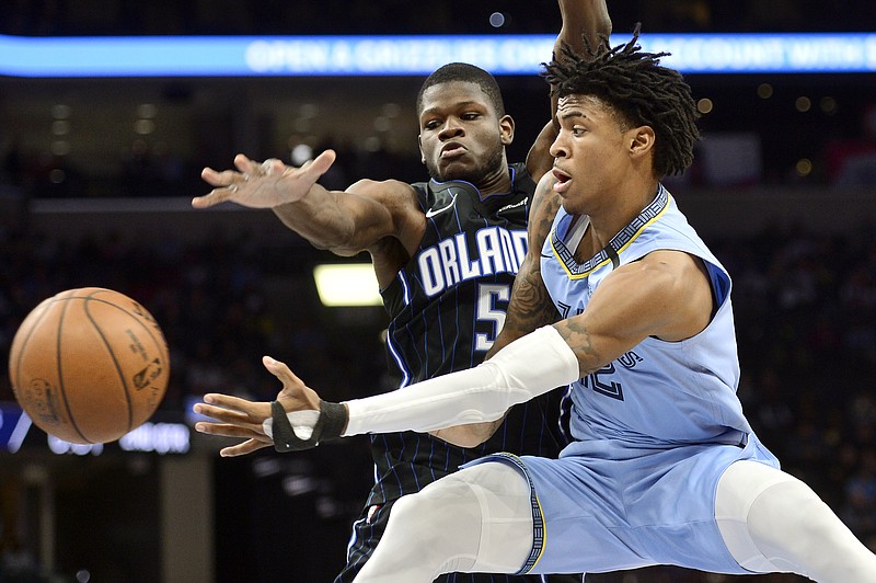 AP photo by Brandon Dill / Memphis Grizzlies guard Ja Morant, right, passes the ball as Orlando Magic center Mo Bamba defends on March 10 in Memphis