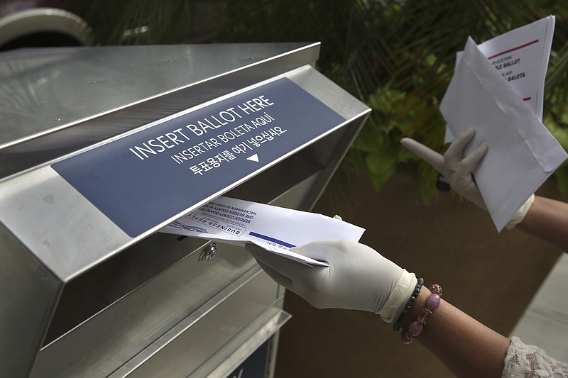 FILE - In this July 7, 2020, file photo a woman wearing gloves drops off a mail-in ballot at a drop box in Hackensack, N.J. After months of hearing President Donald Trump denigrate mail-in balloting, Republicans in the critical battleground state now find themselves far behind Democrats in the perennial push to urge their voters to vote remotely. While Democrats have doubled the number of their voters who've asked for a mail ballot compared to 2016, Republicans have only increased by about 20% since the same time. (AP Photo/Seth Wenig, File)


