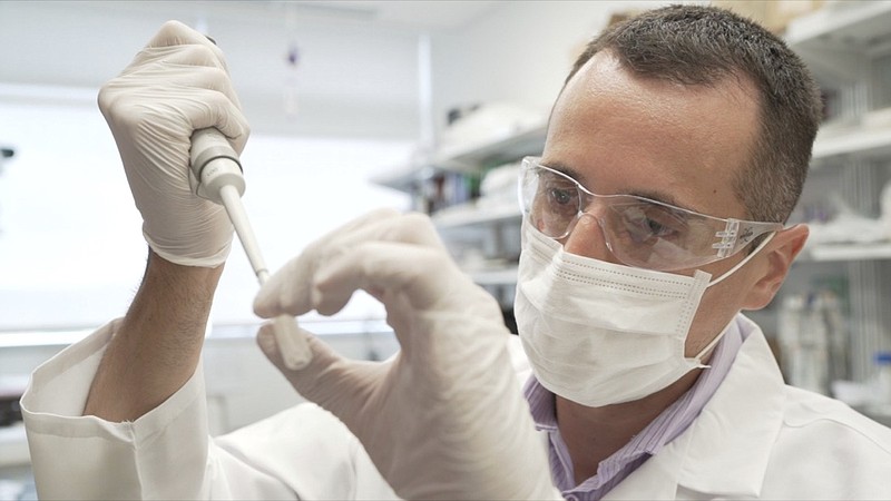 In this image from video provided by Washington University, researcher Nicolas Barthelemy works on a p-tau217 test for Alzheimer's disease at a laboratory in St. Louis, Mo., on Monday, July 27, 2020. Several companies and universities have developed versions of these tests, which look for a form of tau protein, one of the substances that can build up and damage the brains of people with Alzheimer's. (Huy Mach/University of Washington via AP)