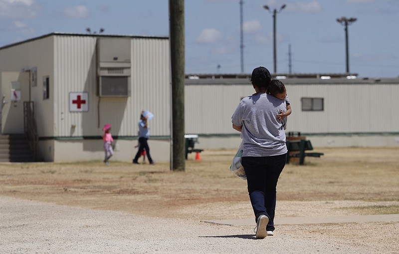 FILE - Immigrants seeking asylum walk at the ICE South Texas Family Residential Center, Friday, Aug. 23, 2019, in Dilley, Texas. The U.S. government did not release 100 immigrant children detained with their parents despite this week's deadline set by a judge who had described family detention centers as "on fire" due to the threat of the coronavirus. U.S. Immigration and Customs Enforcement said Tuesday, July 28, 2020 that it was in compliance with Judge Dolly Gee's June 26 order, which originally set a July 17 deadline for the release of all children held by ICE for more than 20 days. (AP Photo/Eric Gay, File)