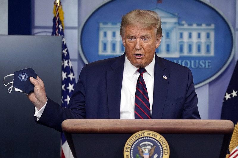 Photo by Evan Vucci of The Associated Press / President Donald Trump holds a face mask as he speaks during a news conference at the White House on Tuesday, July 21, 2020, in Washington.