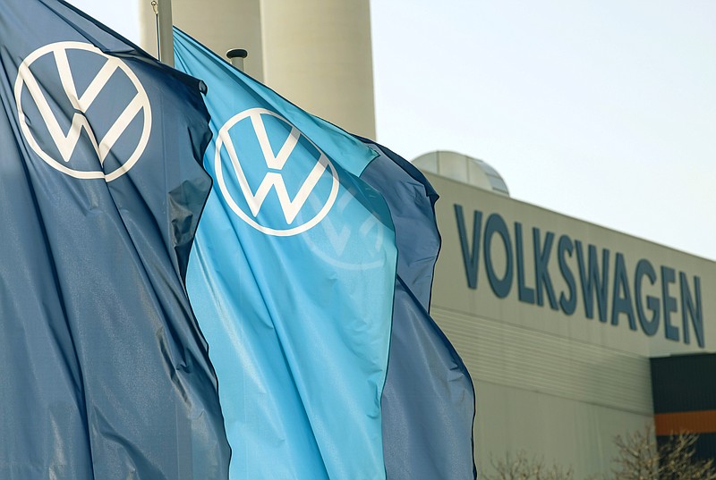 FILE - In this file photo dated Thursday, April 23, 2020, flags wave in front of a factory building during the production restart of the plant of the German manufacturer Volkswagen AG (VW) in Zwickau, Germany. Carmaker Volkswagen reports Thursday July 30, 2020, an after-tax loss of 1.54 billion euros (dollars 1.81 billion) in the second quarter as the pandemic shut down auto plants and closed dealerships. (AP Photo/Jens Meyer, FILE)