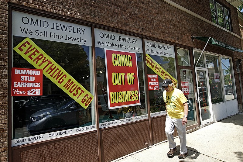 A man walks past a retail store that is going out of business due to the coronavirus pandemic in Winnetka, Ill., Tuesday, June 23, 2020. More than 1.4 million laid-off Americans applied for unemployment benefits last week, reported Thursday, July 30, further evidence of the devastation the coronavirus outbreak has unleashed on the U.S. economy. (AP Photo/Nam Y. Huh)