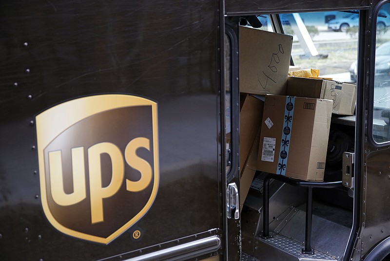  In this Dec. 19, 2018, file photo packages await delivery inside of a UPS truck in Baltimore. United Parcel Service Inc. reported a 13% drop in first-quarter profit, to $965 million, as stay-at-home orders generated deliveries to people's homes but not enough to offset the higher costs and a drop in business deliveries. UPS said Tuesday, April 28, 2020 that the coronavirus outbreak has created "significant headwinds." (AP Photo/Patrick Semansky, FIle)