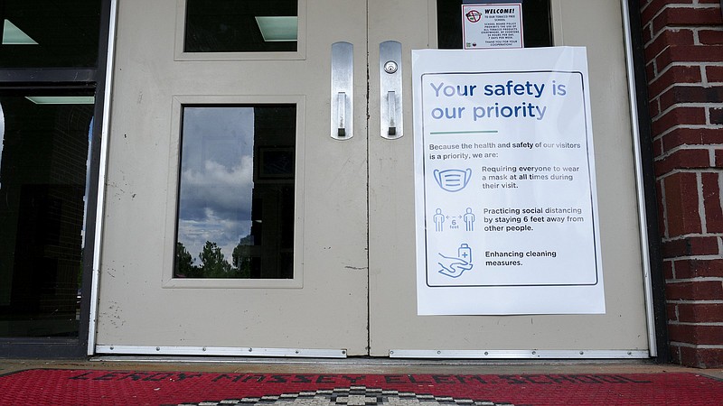 Staff photo by C.B. Schmelter / A sign outlining safety measures hangs on the door at Leroy Massey Elementary School on Tuesday, July 28, 2020 in Summerville, Ga.