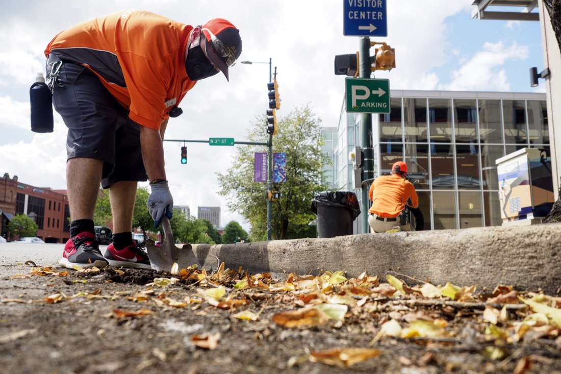 Staff photo by C.B. Schmelter / Downtown Chattanooga Alliance Clean Ambassador Kyle Stone cleans up along the curb on Broad Street on Saturday, Aug. 1, 2020 in Chattanooga, Tenn.